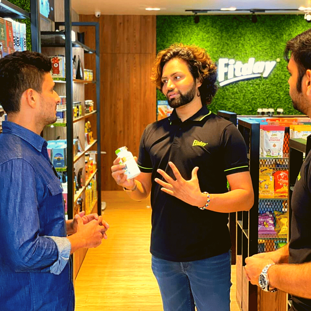 Mr.-Suresh-Raju-Founder-of-Fitday-talking-to-a-custormer-about-their-products-in-the-store-alongside-the-store-Nutritionist.